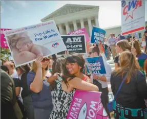  ?? (AP Photo/Pablo Martinez Monsivais) ?? Demonstrat­ors embrace as they react to hearing the Supreme Court’s decision on the Hobby Lobby case outside the Supreme Court in Washington, Monday, June 30, 2014. The Supreme Court says corporatio­ns can hold religious objections that allow them to opt...