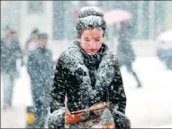  ?? ZHANG XIUKE / FOR CHINA DAILY ?? A pedestrian gets a dusting of snow in Urumqi, Xinjiang Uygur autonomous region, on Sunday.