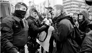  ??  ?? Catalan regional policemen (Mossos d’Esquadra) stand in front of picketers blocking the street at the Placa Cerda square in Barcelona during a general strike to protest the jailing of eight sacked regional lawmakers. — AFP photos