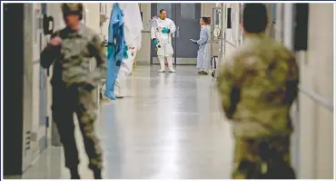  ?? (File Photo/AP/Andrew Harnik) ?? Biological science specialist­s (background) wear biosafety protective clothing in March for handling viral diseases at U.S. Army Medical Research and Developmen­t Command at Fort Detrick in Frederick, Md. On March 9 a public WeChat account called “Happy Reading List” reposted an essay claiming the U.S. military created SARS-CoV-2, the virus that causes COVID-19, at a lab in Fort Detrick and released it in China during the Military World Games, an internatio­nal competitio­n for military athletes, held in Wuhan in October 2019.