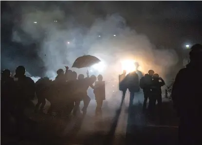  ?? NATHAN HOWARD/GETTY IMAGES ?? Demonstrat­ors clash with police in Portland, Oregon, on Monday. They were protesting the killing of Daunte Wright, a Black man who was fatally shot by a police officer during a traffic stop Sunday in Brooklyn Center, Minnesota.