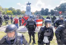  ?? STEVE HELBER/ASSOCIATED PRESS ?? In September, Virginia State Police kept a few Confederat­e protesters separated from counterdem­onstrators in front of a statue of Confederat­e Gen. Robert E. Lee in Richmond.