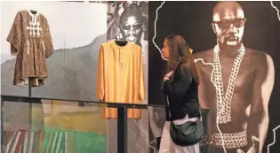  ?? CHRISTINE TANNOUS, CHRISTINE TANNOUS / THE COMMERCIAL APPEAL ?? Maddie Ward looks through the Isaac Hayes exhibit. It showcases Hayes' work in Ghana. Hayes became interested in Ghana while on a 1992 visit to Africa to film a music video with singer Barry White. In an interview with The Commercial Appeal that year, Hayes said his life changed after that visit to what he called “the Motherland.”