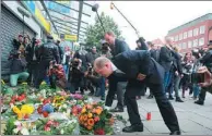  ?? AGENCE FRANCE-PRESSE ?? Hamburg’s mayor Olaf Scholz lays down flowers at a makeshift memorial in front of the supermarke­t.