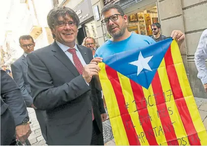  ?? REUTERS ?? Apoyo. El jefe de gobierno catalán, Carles Puigdemont con la bandera catalana y un independen­tista.