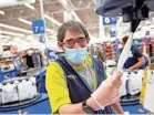  ?? WALMART ?? A Walmart employee wearing a mask and plastic gloves.