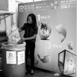  ?? ?? Quality Assurance Manager at Salada Foods Jamaica Limited, Nadine Frances, prepares to drop a bag of plastic bottles into one of the 55-gallon capacity recycling bins at the company’s Bell Road, Kingston 11 office.