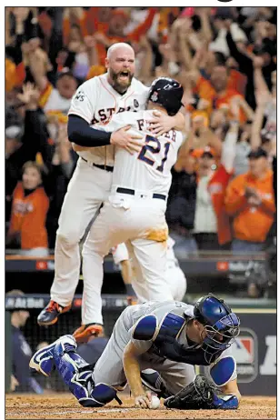  ?? AP/MATT SLOCUM ?? The Astros’ Brian McCann and Derek Fisher (21) celebrate after Fisher scored the winning run on a hit by Alex Bregman during the 10th inning of Game 5 of the World Series against the Dodgers early Monday in Houston. The Astros won 13-12 to take a 3-2...