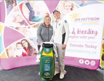  ??  ?? Lynn Redl-huntington, vice-president of communicat­ions with the Jim Pattison Children’s Hospital Foundation, thanks Alena Sharp as she donated a Humboldt Broncos-themed golf bag to the foundation.