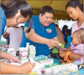  ??  ?? A volunteer doctor explains to a mother how the medicine he had prescribed for her baby should be taken.