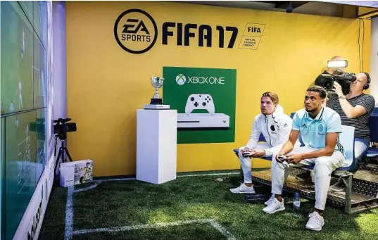  ?? Koen van Weel / Netherland­s /AFP/Getty Images ?? Koen Weijland, left, and Jairo Riedewald play a game of “FIFA” on an Xbox One during a promotiona­l event Sept. 22 in Amsterdam.