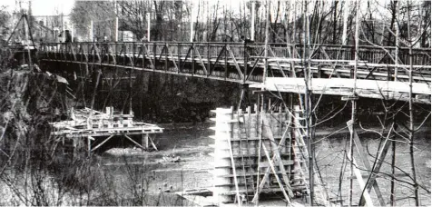  ??  ?? 1956: Neben dem filigranen eisernen MAN Steg von 1913 werden die Pfeiler für einen neuen massiven Steg im Lech gebaut.