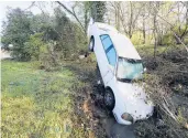  ?? MARKHUMPHR­EY/AP ?? A car that was carried by floodwater­s rests against a tree in a creek Sunday in Nashville, Tennessee.