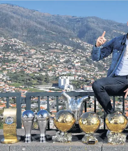  ??  ?? Cristiano Ronaldo poses with his five Ballon d’Or trophies and other awards.