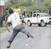  ?? Jorge Rios
European Pressphoto Agency ?? IN GUERRERO STATE, a man throws stones at police. Violence was rampant in the lead-up to voting, but polling was mostly peaceful.