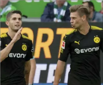  ?? THE ASSOCIATED PRESS ?? Dortmund’s Christian Pulisic, left, celebrates scoring the first goal of the game against Wolfsburg.