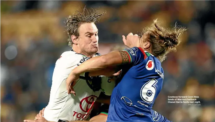  ?? PHOTOSPORT ?? Cowboys forward Coen Hess fends of Warriors halfback Chanel Harris-Tavita last night.