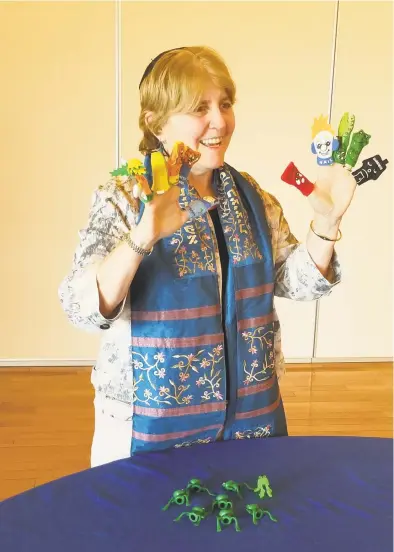  ?? Suanne Ritchey / Contribute­d photo ?? Finger puppets that represent the 10 plagues of Passover can help bring the story alive for children, says Rabbi Laurie Gold. Plastic frogs, on the table, also engage the interest of youngsters.