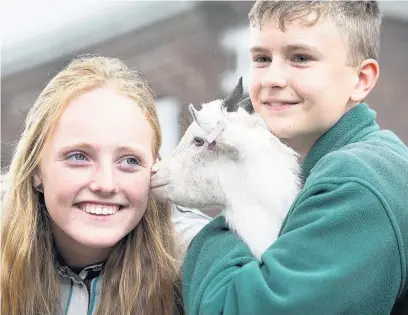  ?? Joel Goodman ?? ●●Students Grace Burke, 14, and Ben Earlam, 13, with Jack the pygmy goat at Reddish Vale High School’s farm