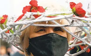  ?? GETTY IMAGES ?? A woman wearing a wreath in the colors of the former white-red-white f lag of Belarus takes part in a rally Sunday in Minsk demanding the freedom of jailed opposition activists.