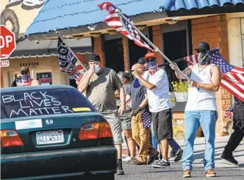  ?? SANDY HUFFAKER PHOTOS ?? Trump supporters demonstrat­e during a Black Lives Matter caravan rally in Lakeside on Sunday.