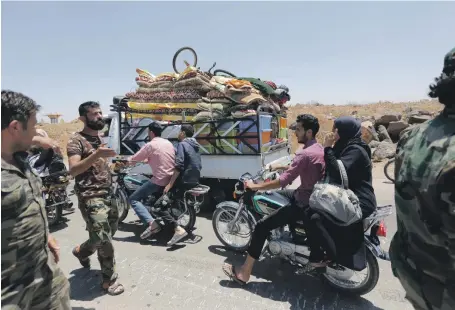  ?? EPA ?? Displaced Syrians on the road home to Saida town near Deraa city in south Syria yesterday, but some still fear going home