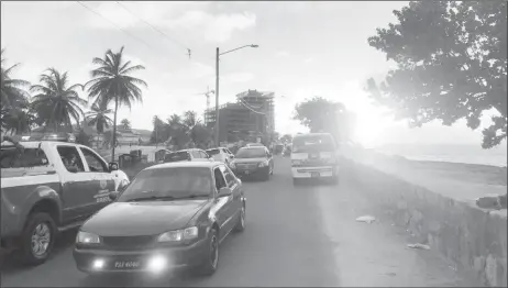  ??  ?? The police patrol vehicle with loudspeake­rs advising persons to remove from the seawall as it approached the curfew yesterday afternoon.