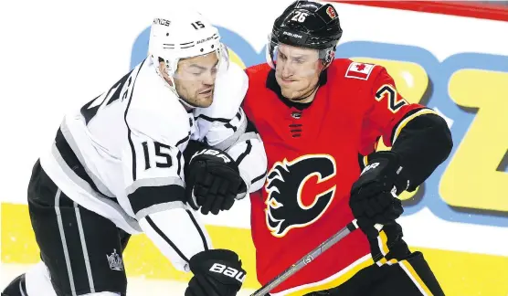  ?? JIM WELLS ?? Kings forward Andy Andreoff and Flames defenceman Michael Stone collide Thursday night during Calgary’s 4-3 victory over Los Angeles at Scotiabank Saddledome.