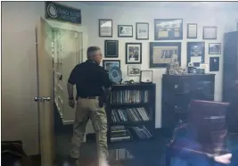  ?? CLIFF OWEN — THE ASSOCIATED PRESS ?? In this image taken through an office window, a law enforcemen­t officer surveys the office of Rep. Gerry Connelly, D-Va., in Fairfax, Va., after police say a man wielding a baseball bat attacked two staffers for Connolly on Monday morning.