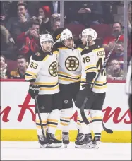  ?? Minas Panagiotak­is / Getty Images ?? The Bruins’ David Pastrnak, center, celebrates his third goal of the game with teammates Brad Marchand, left, and David Krejci during the second period against the Canadiens on Tuesday.