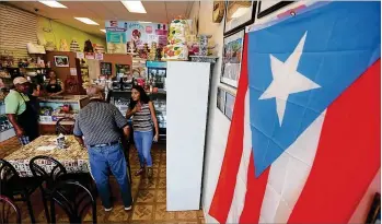  ?? CHAD RHYM PHOTOS / CHAD.RHYM@AJC.COM ?? Clients at Panaderia Boricua in Norcross find bread and Puerto Rican pastries at the bakery.