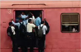  ?? — AFP ?? COLOMBO: Passengers travel in a train in Colombo yesterday. Due to its affordabil­ity, train travel is a popular mode of transport in this nation of 20 million people.