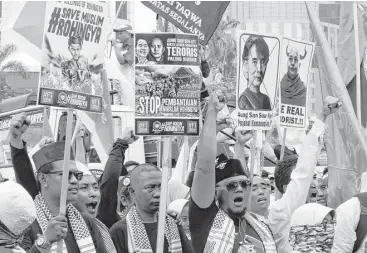  ?? Achmad Ibrahim / Associated Press ?? Muslim protesters in Jakarta, Indonesia, shout slogans and display signs denouncing Myanmar’s state counsellor, Aung San Suu Kyi, and Wirathu, the leader of Myanmar’s nationalis­t Buddhist monks. They were rallying against the treatment of Rohingya...