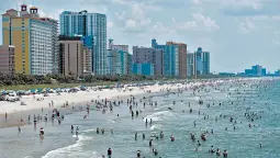  ?? SEAN RAYFORD/GETTY ?? People in the ocean July 4 in Myrtle Beach, South Carolina. Teens have been socializin­g more frequently, leading to a surge in COVID-19 cases in young people.