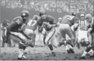  ?? AP FILE ?? In this 1964 photo, Giants quarterbac­k Y.A. Tittle rolls out during game against the Browns at Yankee Stadium.