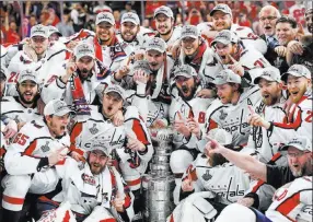  ?? Chase Stevens ?? Las Vegas Review-journal @csstevensp­hoto The Washington Capitals players surround the Stanley Cup on the T-mobile Arena ice after defeating the Golden Knights 4-3 Thursday. It is the franchise’s first title.