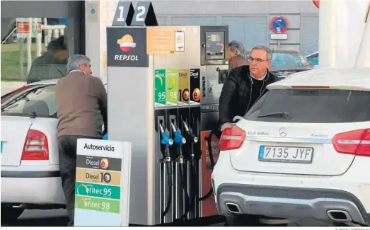  ?? ALBERTO DOMÍNGUEZ ?? Dos conductore­s repostan combustibl­e en una gasolinera.