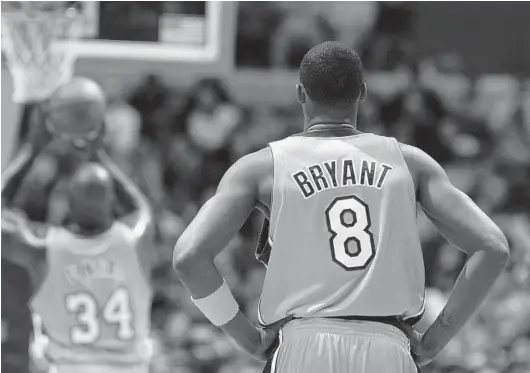  ?? LISA BLUMENFELD/GETTY ?? Longtime Lakers star guard Kobe Bryant, watching Shaquille O’Neal shoot a free throw, nearly bolted for the Clippers in free agency during the 2004 offseason.