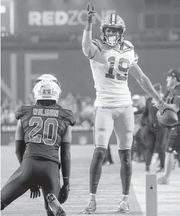  ?? JEFF LEWIS/AP ?? Packers’ Equanimeou­s St. Brown (19) signals first down after a catch against the Cardinals on Thursday.