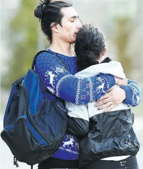  ?? NATHAN DENETTE / THE CANADIAN PRESS ?? Two people comfort each other in Toronto after a van mounted a sidewalk crashing into a number of pedestrian­s on Monday.