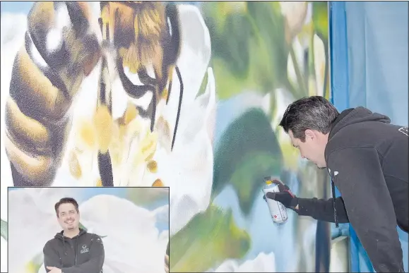  ?? (NWA Democrat-Gazette/Rachel Dickerson) ?? Artist Graham Edwards puts some finishing touches on a mural at the Bella Vista Public Library. He is working on a second one. The theme is "pollinator­s."