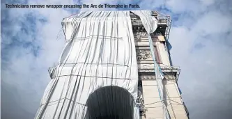  ?? ?? Technician­s remove wrapper encasing the Arc de Triomphe in Paris.