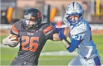  ?? MORGAN TIMMS/THE TAOS NEWS ?? Taos’ senior running back Jonathan Garcia, left, holds off Lovington’s Ayden Garcia during Taos’ 55-7 rout Saturday at Anaya Stadium.