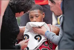  ??  ?? The Bulls’ Kris Dunn is treated by the medical staff after hitting his face on the floor after a dunk during the fourth quarter of Wednesday night’s game against the Golden State Warriors in Chicago. The Bulls announced Thursday that Dunn, the exNew...