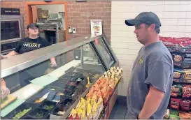  ?? Doug Walker / Rome News-Tribune ?? Kimberly Dunn (left), an employee at the Subway inside the Circle K convenienc­e store at Six Mile, serves lunch to Kevin Laney. Laney was at the head of a long line for lunch.