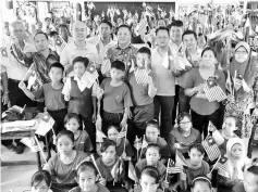  ??  ?? Teng (standing, second row, third left) with pupils and teachers of SK Sungai Paoh wave the Jalur Gemilang as they sing the National Anthem.