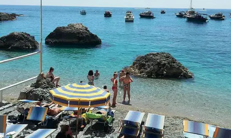  ??  ?? Mare
In alto uno dei lidi balneari dell’isola aperti in anticipo, già con numerosi bagnanti; a sinistra la folla ieri pomeriggio nella Piazzetta