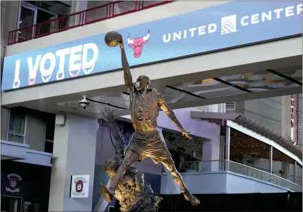  ?? CHARLES REX ARBOGAST — THE ASSOCIATED PRESS ?? The Michael Jordan statue stands in front of an I Voted banner on Election Day, Tuesday, Nov. 3, in the atrium of the United Center, transforme­d for the fi rst time into a super voting site in Chicago.