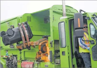  ?? JOE GIBBONS/THE TELEGRAM ?? A City of St. John’s employee demonstrat­es Friday how the extension arm retrieves a bin and lifts it to dump its contents into a garbage truck.