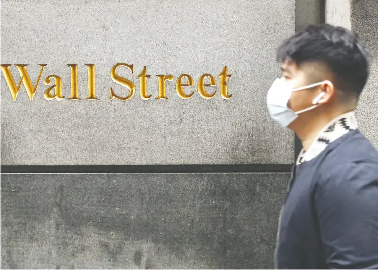  ?? LUCAS JACKSON / REUTERS ?? A man wears a protective mask on Friday as he walks on Wall Street during the coronaviru­s outbreak in New York City.